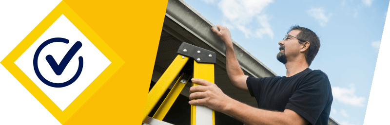 Miami handyman on ladder inspecting roof and gutters service confirmed
